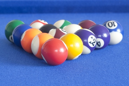 set of pool balls ready to be played on a blue tableの写真素材