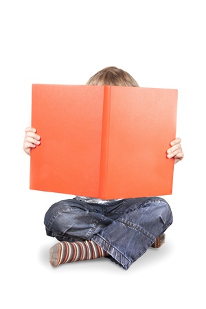 Boy holding up and hif=ding face behind big orange book isolated on a white backgroundの写真素材