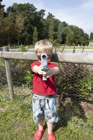 summer in the woods child playing with a pistol gunの写真素材