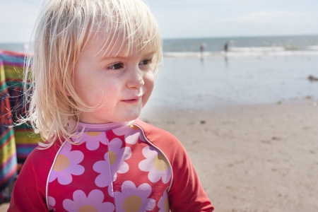 Two or three year old blonde girl in summer at the seasideの写真素材