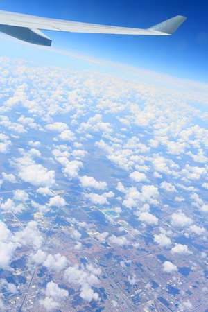 looking down out of a plane onto miami through the clouds hundreds of miles upの写真素材