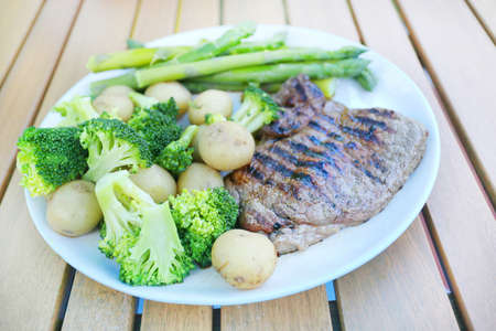 steak, brocolli and veg dinner in the garden outside in the summerの写真素材