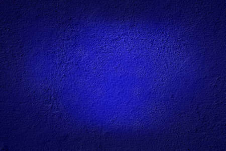 Detailed macro shot of fine blue paint on a textured concrete wallの写真素材