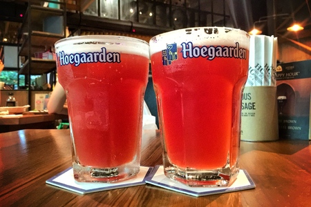 BANGKOK - JUNE 16: Hoegaarden draft Belgium beer in large size glass on counter bar in pub was taken in Bangkok, Thailand, on June 16, 2016.のeditorial素材