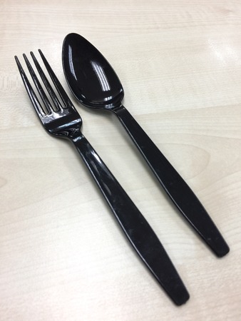 Black plastic spoon and fork on the table