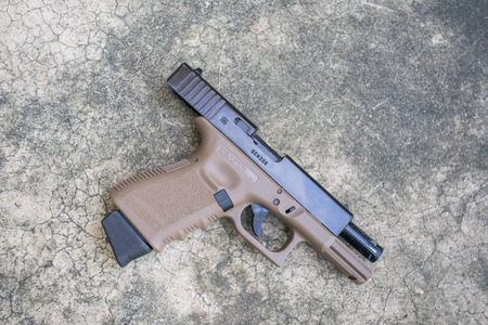 BANGKOK, THAILAND - 29 OCT 2017: Glock 19 two tone airsoft 6 mm bullet ball pistol gun on the floorのeditorial素材