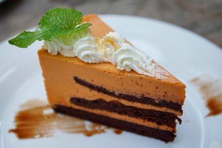 Layer of Thai tea cake and whip cream on the wood tableの写真素材