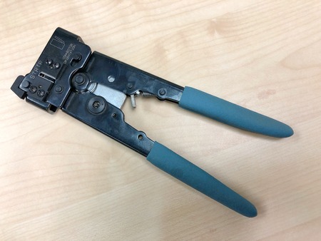 The pliers tool with blue handles for crimping a connector to network and telephone cable