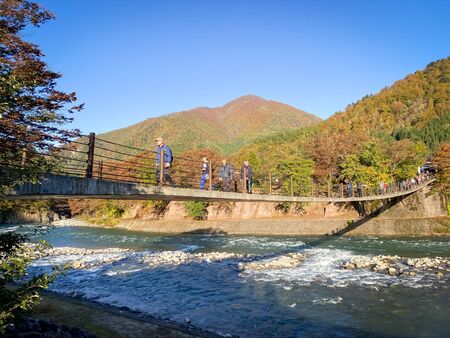 Shirakawa Japan - 12 Nov 2019: Many people waking on the bridge over Sho River in autumn at Shirakawago village,Gifu Japanのeditorial素材