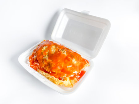 Omelet with pork and chili sauce on rice in the white food trayの写真素材