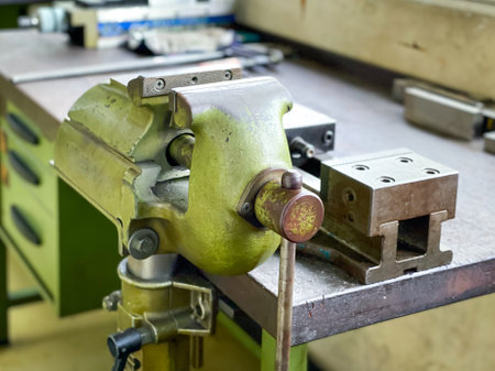 Old vise installed on table equipment for work in the factory