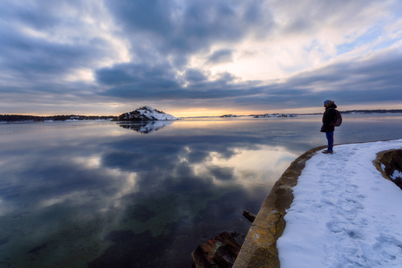 Young adult enjoying sunset and the nice reflection of island in an ocean. Gotneburg,Sweden 2018のeditorial素材
