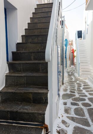 Narrow streets and blue windows with white buildings in Mykonos Greeceの写真素材
