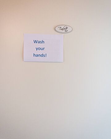 Wash your hands notice next to toilet sign with empty space on a white background , Swedenの写真素材