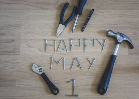 Carpentery tools placed on wooden floor with happy mady first written with arragement of...