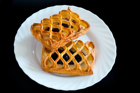 twist buns with jam on white plate isolated on black backgroundの写真素材