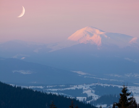 Moon over snow-covered peak. Early morningの写真素材
