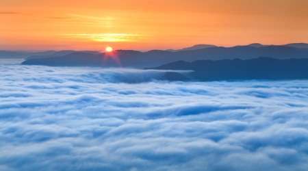 Sunrise over the sea of fog in the mountains at the summerの写真素材