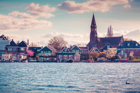 Authentic Holland architecture on the water channel in Zaanstad village. Zaanse Schans Windmills and famous Netherlands canals, Europe.の写真素材