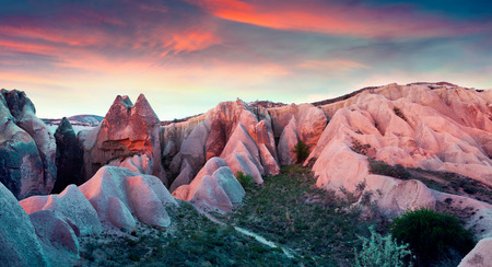 Unreal world of Cappadocia. Sunset in Red Rose valley in April. Cavusin village located, district of Avanos in Nevsehir Province in the Cappadocia region of Turkey, Asia.の写真素材