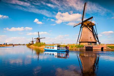 Walking boat on the famous Kinderdijk canal with windmills. Old Dutch village Kinderdijk