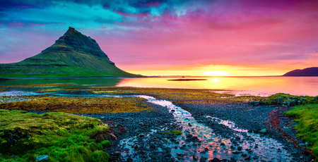 Colorful summer sunset with Kirkjufell mountain. Dramatic scene on Snaefellsnes peninsula with fall of tide in Atlantic ocean, Iceland, Europe.の写真素材