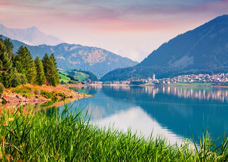 Splendidt summer sunrise on Resia (Reschensee) lake. Resia village in the morning mist,  Province of Bolzano - South Tyro, Italyの写真素材