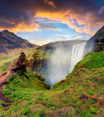 Picturesque  morning view of Skogafoss Waterfall on Skoga river. Dramatic summer sunrise in Iceland, Europe. Artistic style post processed photo.の写真素材