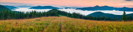 Foggy morning panorama of Carpathian mountains. Colorful summer morning on the mountain valley, Tatariv village location, Ukraine, Europe. Beauty of nature concept background.の写真素材