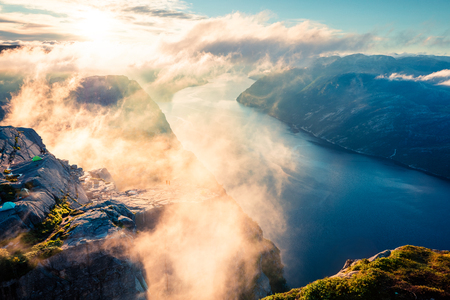 Foggy morning view of popular Norwegian attraction Preikestolen. Great summer scene of the Lysefjorden fjord, located in the Ryfylke area in southwestern Norway. Beauty of nature concept background.の写真素材