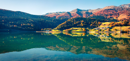 Incredible autumn panorama of Resia village and lake. Amazing morning scene of Italian Alps, South Tyrol, Italy, Europe. Traveling concept background.の写真素材