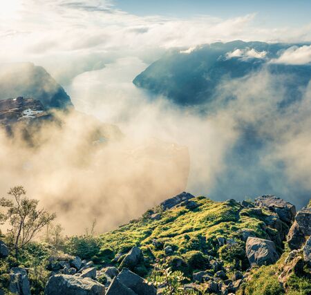 Foggy morning view of popular Norwegian attraction Preikestolen. Aerial summer scene of the Lysefjorden fjord, located in the Ryfylke area in southwestern Norway.の写真素材