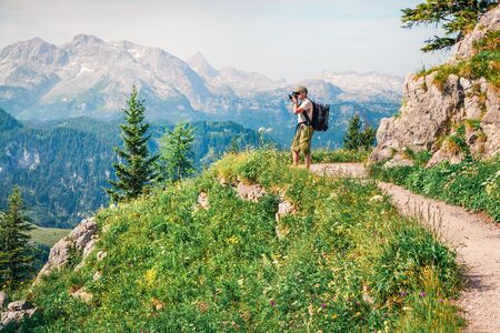 Photographer takes picture above the Konigsee lake of Schneibstein mountain ridge. Colorful summer morning on a border of Germany and Austrian Alps. Berchtesgaden location, Germany.の写真素材
