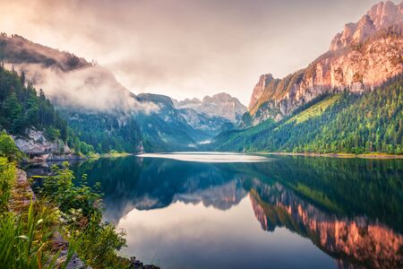 Perfect summer sunrise on Vorderer ( Gosausee ) lake with Dachstein glacier on background. Mystical morning view of Austrian Alps, Upper Austria, Europe. Beauty of nature concept background.の写真素材