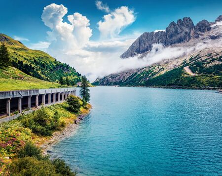 Splendid morning view of Fedaia lake. Colorful summer scene of Dolomiti Alps, Gran Poz location, Trentino-Alto Adige/Sudtirol region, Italy, Europe. Beauty of nature concept background.の写真素材