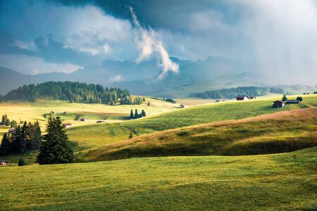 Rainy evening scene of Compaccio village, Seiser Alm or Alpe di Siusi location, Bolzano province, South Tyrol, Italy, Europe. Fantastic summer view of Dolomiti Alps. Beauty of countryside concept background.の写真素材
