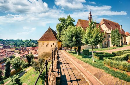 Amazing morning cityscape of Sighisoara with Evangelical Church on background. Sunny summer view of medieval town of Transylvania, Romania, Europe. Traveling concept background.の写真素材