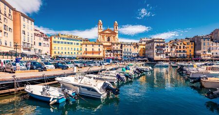 Panoramic summer cityscape of Bastia port with twin-towered Church of St. Jean-Baptiste rising behind it. Stunning afternoon view of Corsica island, France, Europe. Bright Mediterranean seascape.の写真素材