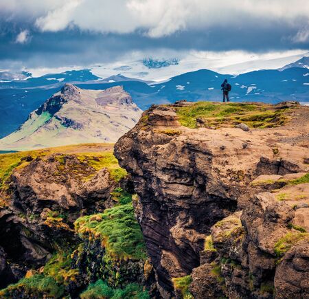 Photographer takes picture on the edge of cliff. Stunning summer view of Dyrholaey Nature reserve. Splendid morning scene of southern Iceland, Europe. Traveling concept background.
の写真素材