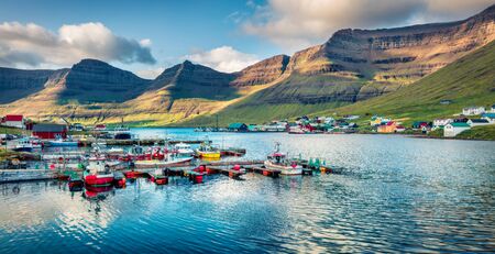 Panoramic morning view of Hvannasund port and village, Vidoy island. Calm summer scene of fjord on Atlantic ocean. Beautiful landscape of Faroe Islands, Kingdom of Denmark, Europe.の写真素材