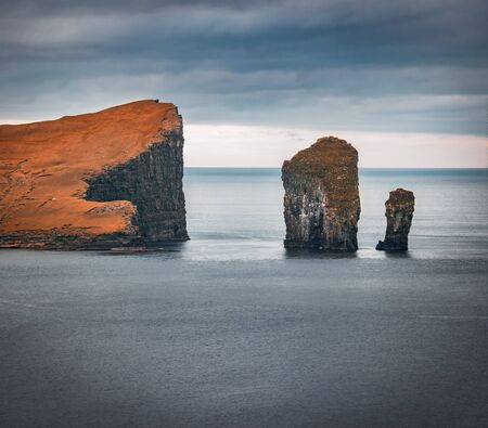Dramatic autumn view of Drangarnir cliffs on Vagar island. Gloomy morning scene of Faroe Islands, Kingdom of Denmark, Europe. Beauty of nature concept background.の写真素材