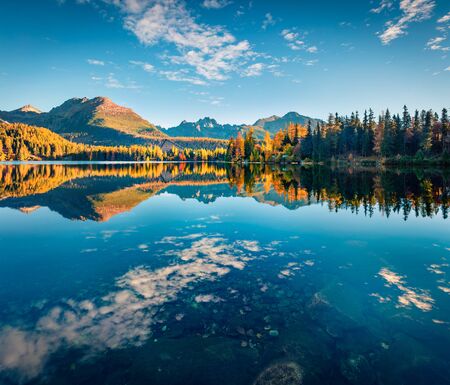 Deep blue sky reflected in calm waters of Strbske pleso lake. Picturesque morning scene of High Tatras National Park, Slovakia, Europe. Beauty of nature concept background.の写真素材
