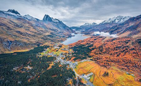 View from flying drone. Gloomy autumn view of Sils lake. Dramatic morning scene of Swiss Alps. Aerial outdoor scene of Maloya village, Switzerland, Europe. Beauty of nature concept background.の写真素材