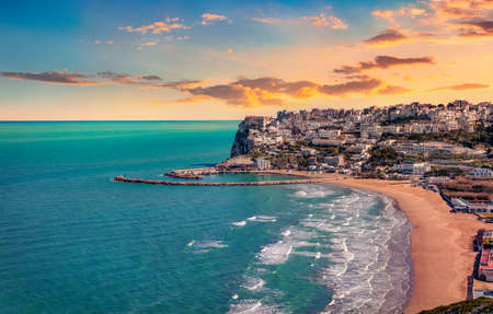 View from flying drone. Picturesque summer cityscape of Peschici town, Province of Foggia, Italy, Europe. Dramatic sunrise on Adriatic sea. Traveling concept background.の写真素材