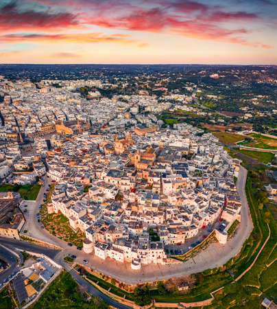 View from flying drone. Magnificent summser sunrise in Ostuni town. Aerial morning cityscape of Apulia, Italy, Europe. Traveling concept background.の写真素材