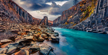 Basalt cliffs in deep canyon of mountain river. Dramatic spring view of Studlagil Canyon. Exciting...