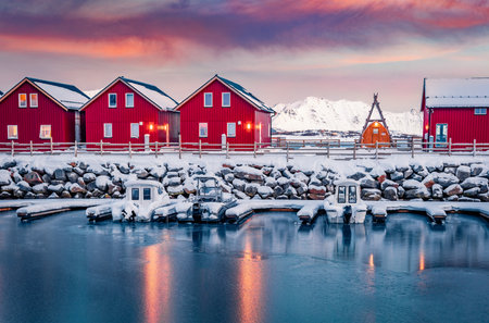 Typical red wooden houses on the shore of Offersoystraumen fjord. Stunning winter sunrise on Vestvagoy island. Colorful mornig view of Lofoten Islands, Norway, Europe. Life over polar circle.の写真素材