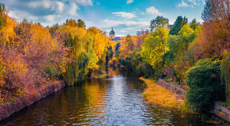 Sunny autumn view of Seret river in Ternopil city park with Church of Saints Volodymyr and Olha on...