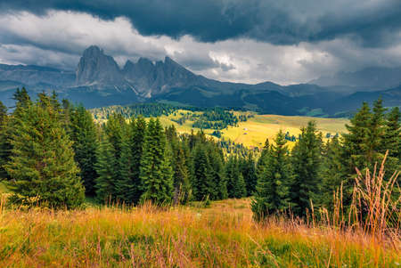Dramatic Alps scenery. Rainy morning view of Compaccio village, Seiser Alm or Alpe di Siusi location, Italy, Europe. Fantastic summer scene of Dolomite Alps. Travel concept background.の写真素材