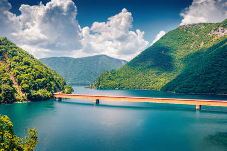 Bright summer view of Pivsko lake with bridge. Picturesque morning scene of canyon of Piva river,...